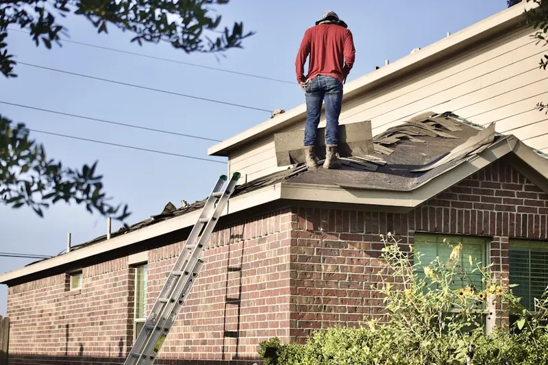 Professional roofer working on a residential roof in Fort Logan